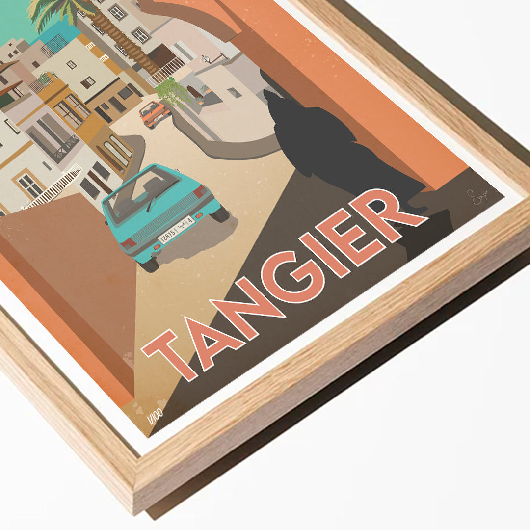Framed artwork of a city street with a car and 'Tangier' text, featuring a wooden frame.